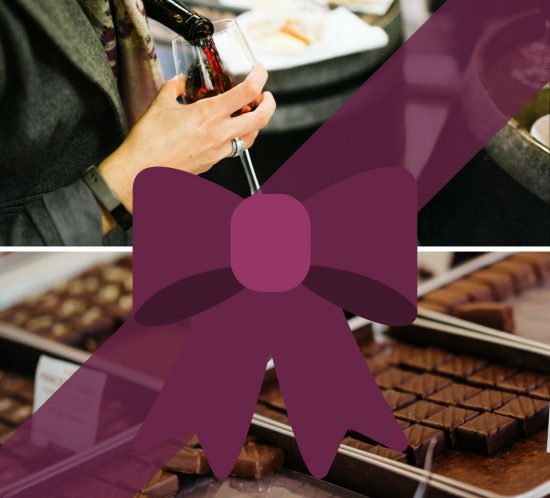 A person pours red wine into a glass above a table with food. Below, trays of assorted chocolates are displayed, partially covered by a large purple ribbon and bow graphic—a perfect scene for any Taste of Toulouse Gift Guide.