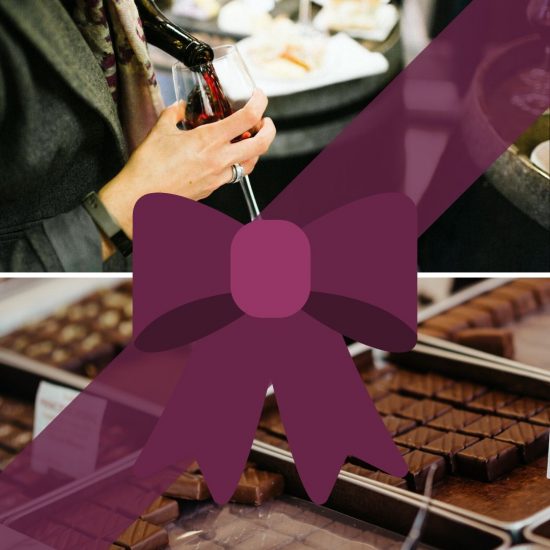 A person pours red wine into a glass above a table with food. Below, trays of assorted chocolates are displayed, partially covered by a large purple ribbon and bow graphic—a perfect scene for any Taste of Toulouse Gift Guide.