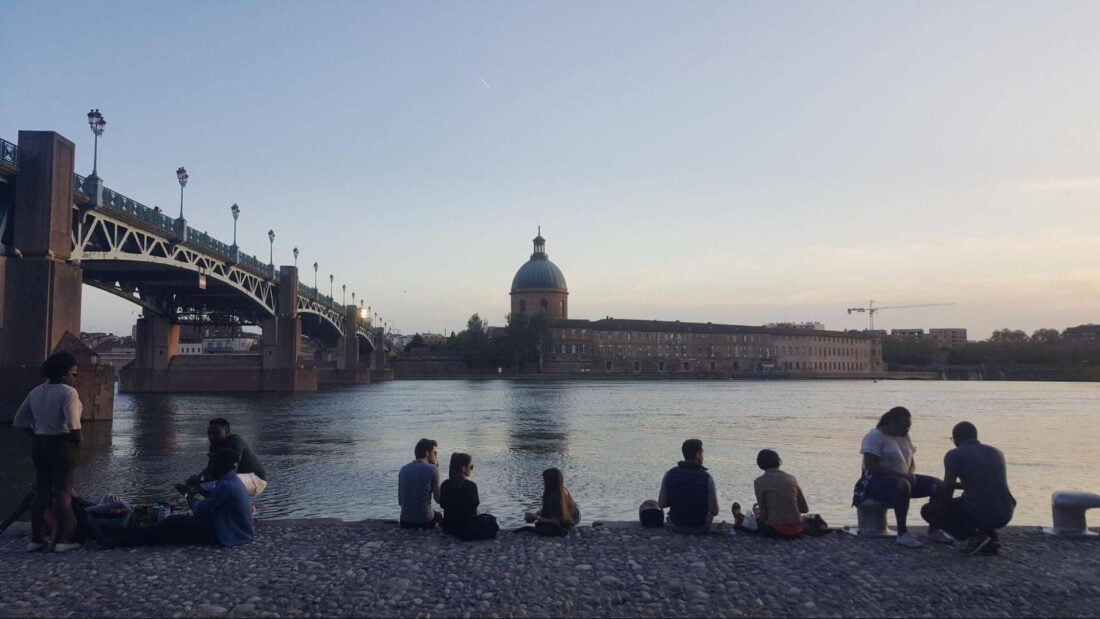 People sitting by Garonne river
